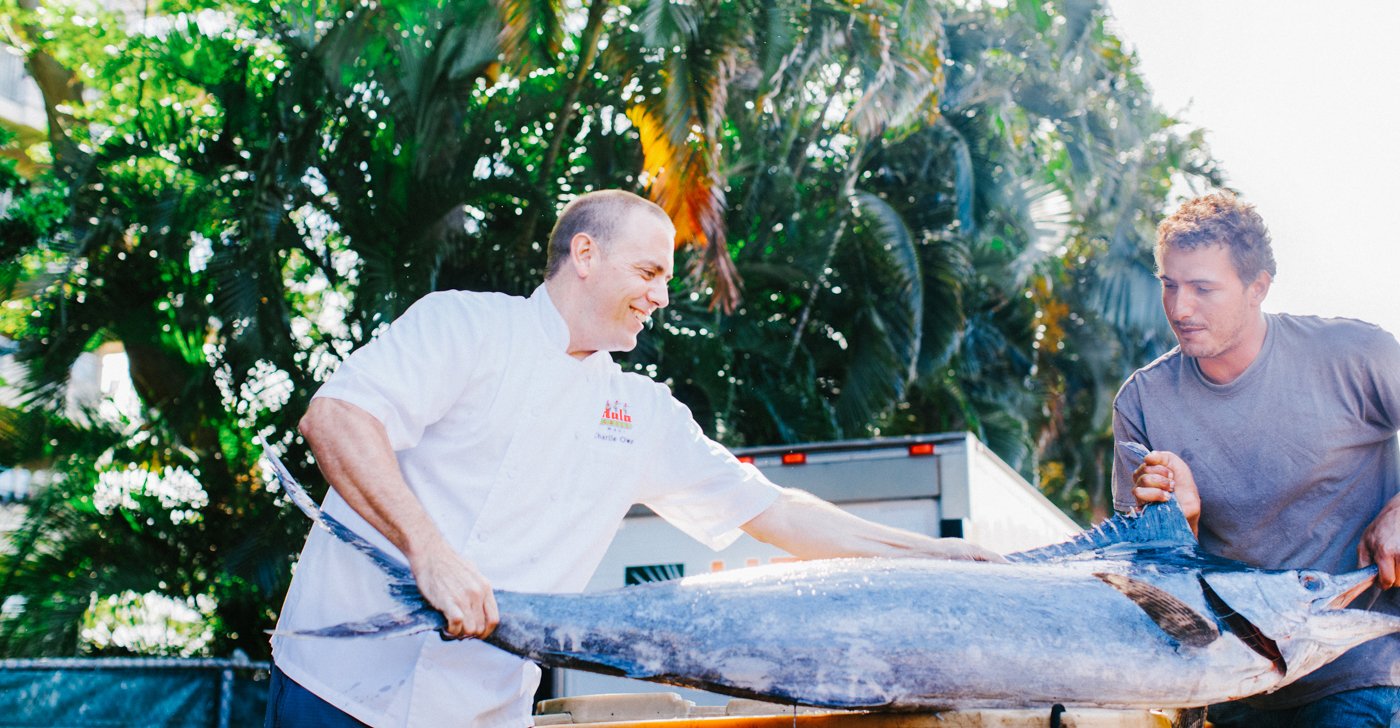 Two chefs handling fresh fish